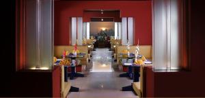 a restaurant with tables and chairs in a room with red walls at CLUB7 HOTEL in Thiruvalla
