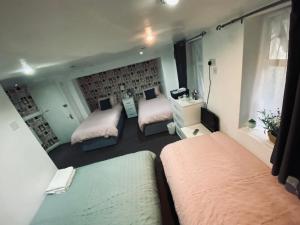 a small bedroom with two beds and a mirror at Shiray Hotel in Blackpool