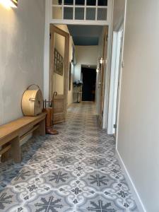 a hallway with a tile floor and a bench at B&B l'histoire de l'éclair in Bruges