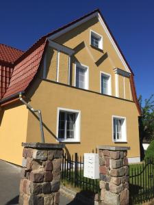 ein großes gelbes Haus mit einem schwarzen Zaun in der Unterkunft Haus Galgenbruch in Feldberg