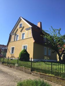 ein gelbes und grünes Haus mit einem schwarzen Zaun in der Unterkunft Haus Galgenbruch in Feldberg