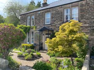 a brick house with a garden in front of it at Lynwood - Victorian Home in the Peak District in Bakewell
