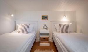 2 camas blancas en una habitación con mesita de noche en Backhaus Ost, en Bisdorf