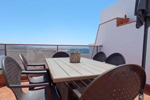 a wooden table and chairs on a balcony at Casa Las Olas in Cotillo