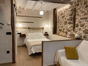 a bedroom with two beds and a stone wall at Apartamento La Herrerita in Candelario
