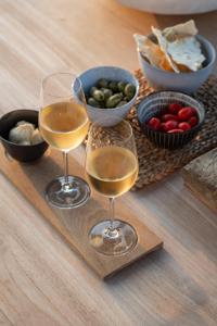 two glasses of wine on a wooden tray with food at Maison Colette in Beauraing