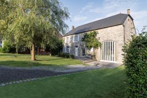an old brick building with a tree in front of it at Maison Colette in Beauraing