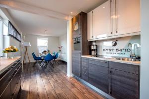 een keuken met houten vloeren en kasten en een eetkamer bij KYST 5410 Floating Home 1 in Neustadt in Holstein