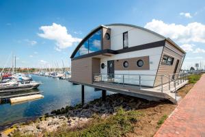 a house on a dock in a body of water at KYST 5410 Floating Home 1 in Neustadt in Holstein