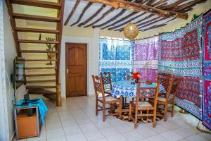 a dining room with a table and chairs and a window at 3 Bed Cottage Sleeps 6- Pool Chef Option Parking in Diani Beach +32 photos