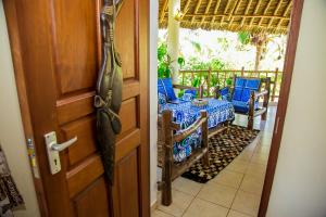 an open door to a porch with a table and chairs at 3 Bed Cottage Sleeps 6- Pool Chef Option Parking in Diani Beach
