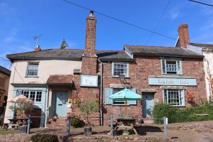 un vecchio edificio di mattoni con un orologio sopra di The Lamb Inn a Crediton