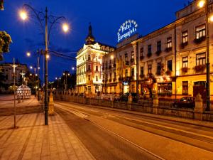 a city street at night with buildings and street lights at Hotel Europejski in Krakow