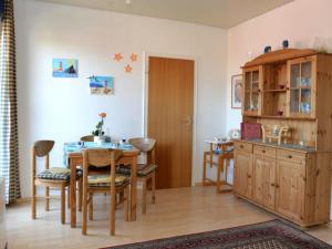 eine Küche und ein Esszimmer mit einem Tisch und Stühlen in der Unterkunft Fewo 91 WHG C 21 in Burhave in Burhave