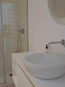 a bathroom with a white sink and a shower at Palmeira Comfort in Aveiro
