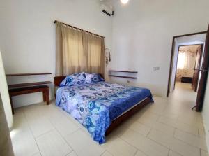 1 dormitorio con 1 cama con edredón azul en Relax On The Caribbean, en Río San Juan