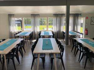 ein Esszimmer mit Tischen, Stühlen und Fenstern in der Unterkunft Gråbogården event and conference center in Gråbo