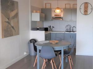 uma cozinha com mesa e cadeiras num quarto em Résidence Estey T2 centre avec aperçu Bassin em Andernos-les-Bains