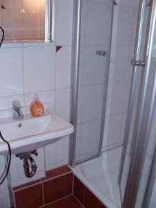 a white bathroom with a sink and a shower at Jenatschek, FP, N-1-2 in Heiligenhafen