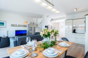 uma cozinha e sala de estar com uma mesa de madeira com flores em Ostsee - Maisonette - Appartement Nr 49 "Weitsicht" im Strand Resort em Heiligenhafen