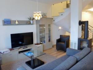uma sala de estar com um sofá e uma televisão em Ostsee - Maisonette - Appartement Nr 49 "Weitsicht" im Strand Resort em Heiligenhafen
