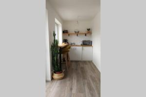 cocina con armarios blancos y suelo de madera en Parenthèse nature, en Soultz-Haut-Rhin