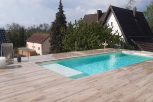 a swimming pool on top of a house with a wooden deck at Parenthèse nature in Soultz-Haut-Rhin