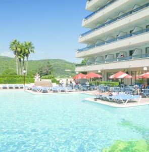 Un complejo con piscina y sillas y un edificio. en Tropic Park, en Malgrat de Mar