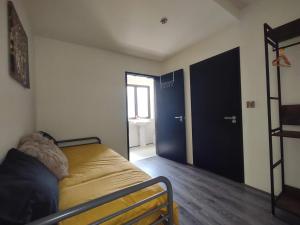 a bedroom with a bed and a door to a bathroom at Ballymakeever Apartment And Spa in Derry Londonderry