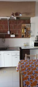 a kitchen with white cabinets and a brick wall at Alojamiento para Grupos in Belén