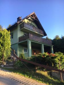 a house with balconies on the side of it at Słoneczny domek in Brenna