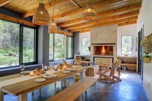 a dining room with a table and a fireplace at Boshuis Farm Stay in George