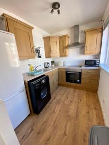 een keuken met een wasmachine en een vaatwasser bij Central Lisburn Duplex Apartment Siren Stays in Lisburn