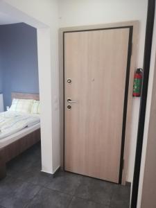 a wooden door in a room with a bed at Apartment by the Sea,Neoi Epivates Beach, Thessaloniki in Neoi Epivates