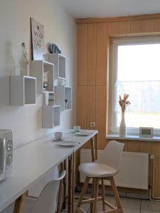 a kitchen with a white counter and white chairs at Seerose in Görlitz
