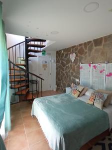 a bedroom with a large bed and a staircase at Pensión Isla - Couples Only in Casas de Cuadra