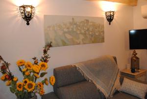 - un salon avec un canapé, des fleurs et un tableau dans l'établissement Casa Michèle in the Historic Center, à Vejer de la Frontera