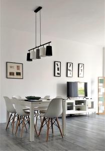 a white dining room with a table and chairs at Casa Giustiniano - Metro San Paolo in Rome