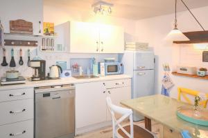 a kitchen with white cabinets and a table at Ziegenmarktidylle im zweitältesten Haus von Röbel in Röbel