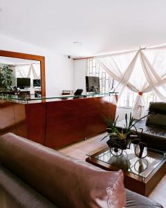 un soggiorno con divano e scrivania di Hotel Marbella Chico a Bogotá