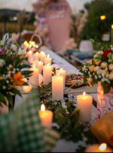 a bunch of candles sitting on a table with flowers at Sunny Funny House in Čačak +24 photos