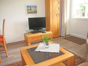a living room with a tv and a coffee table at "Landhaus Voss" Typ 1 Nr2 in Staberdorf