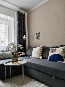 Una sala de estar con un sofá azul y una mesa. en The good stay, en Šiauliai