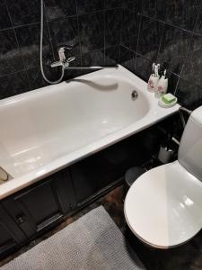 a bathroom with a white toilet and a bath tub at The good stay in Šiauliai +12 photos