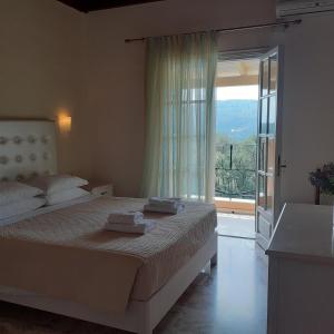 
a hotel room with a bed and a window at RoyalRose in Paleokastritsa
