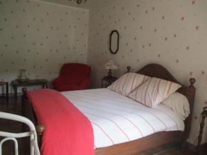 - une chambre avec un lit et une chaise rouge dans l'établissement LA HETRAIE, à Vergetot