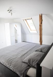 a white bedroom with a bed with a skylight at Ferienwohnung Neubörger mit Hottub in Neubörger