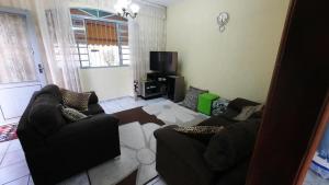 uma sala de estar com dois sofás e uma televisão em Casa do Descanso em São Bento do Sapucaí em São Bento do Sapucaí