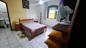 un dormitorio con una cama y una ventana en Casa do Descanso em São Bento do Sapucaí, en São Bento do Sapucaí