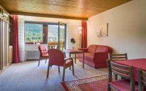 ein Wohnzimmer mit einem Sofa, einem Tisch und Stühlen in der Unterkunft Drei Tannen - Wohnung 04 - Apartmenthaus, Titisee, nahe Badeparadies in Titisee-Neustadt